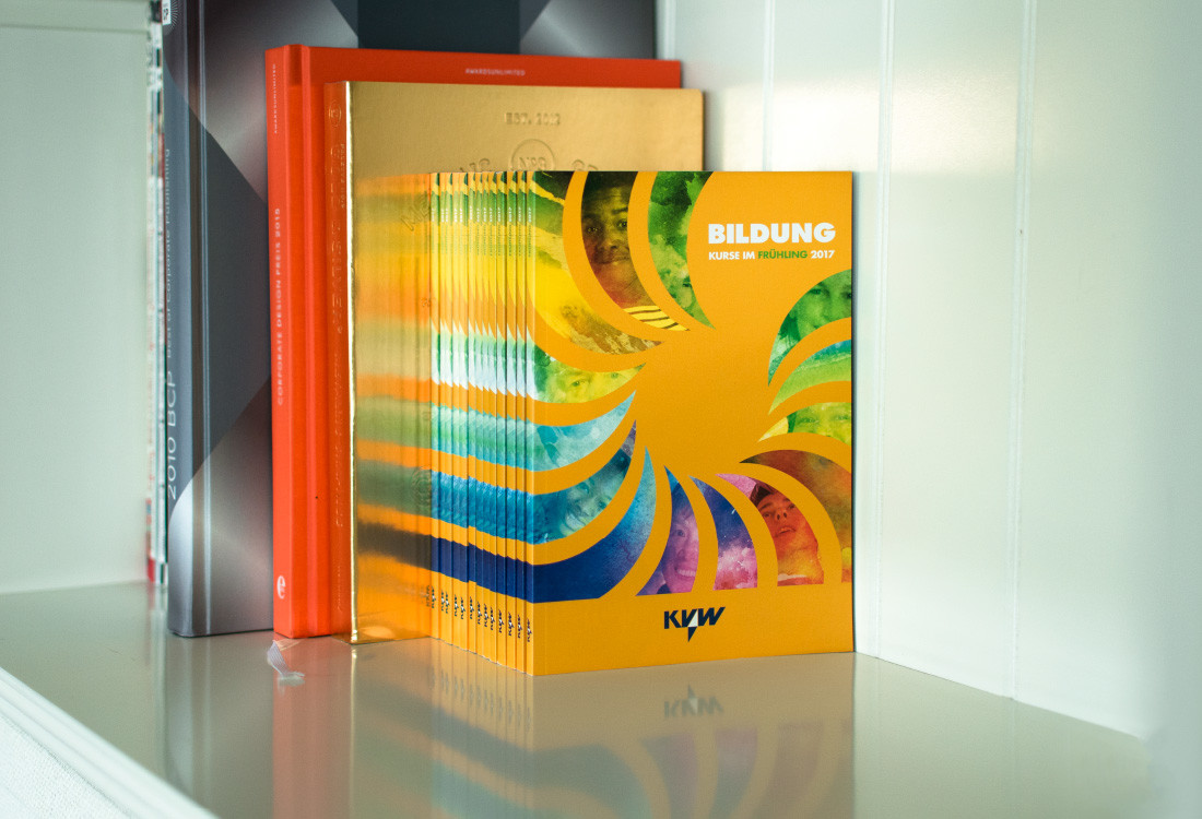 Cover kvw: Aquarell Malerei in Regenbogenfarben mit Gesichtern von Flüchtlingen in Bozen, Illustration und Integration. Design Waldemar Kerschbaumer adpassion